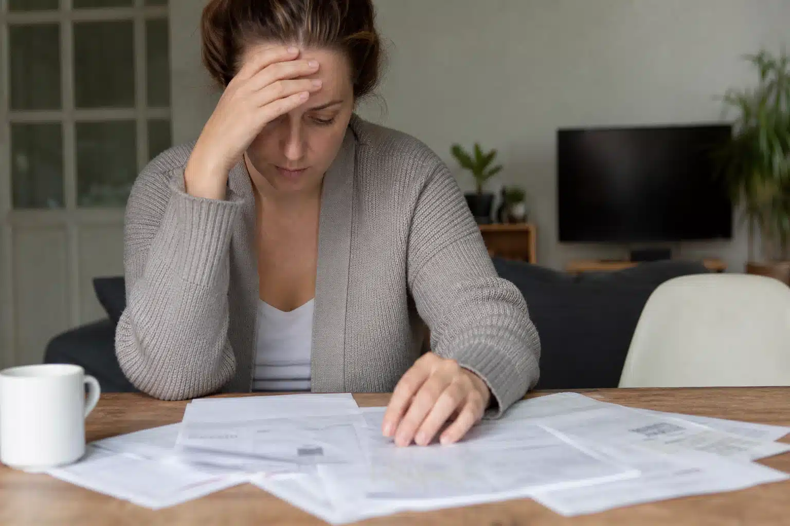 Femme stressée examinant des factures sur la table